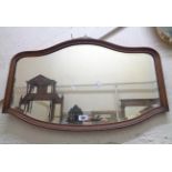 An early 20th Century oak framed wall mirror with shaped bevelled plate