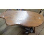 A 77cm rustic hardwood coffee table with shaped top and iron nail decoration, set on shaped
