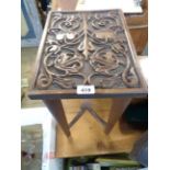 A 35cm stained mixed wood occasional table with decorative carved panel top, set on slender supports