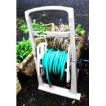 A garden hose reel, set on a wheeled base