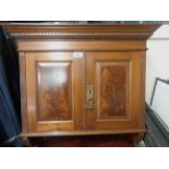 A 63cm Edwardian mahogany wall hanging two door cupboard with dentil cornice and curved brackets