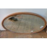 A wooden framed bevelled oval wall mirror from a dressing chest