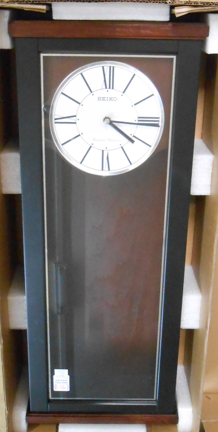 A Seiko QXH062K polished wood cased wall clock with visible pendulum, glazed door and quartz
