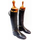 A pair of old leather riding boots with wooden boot trees