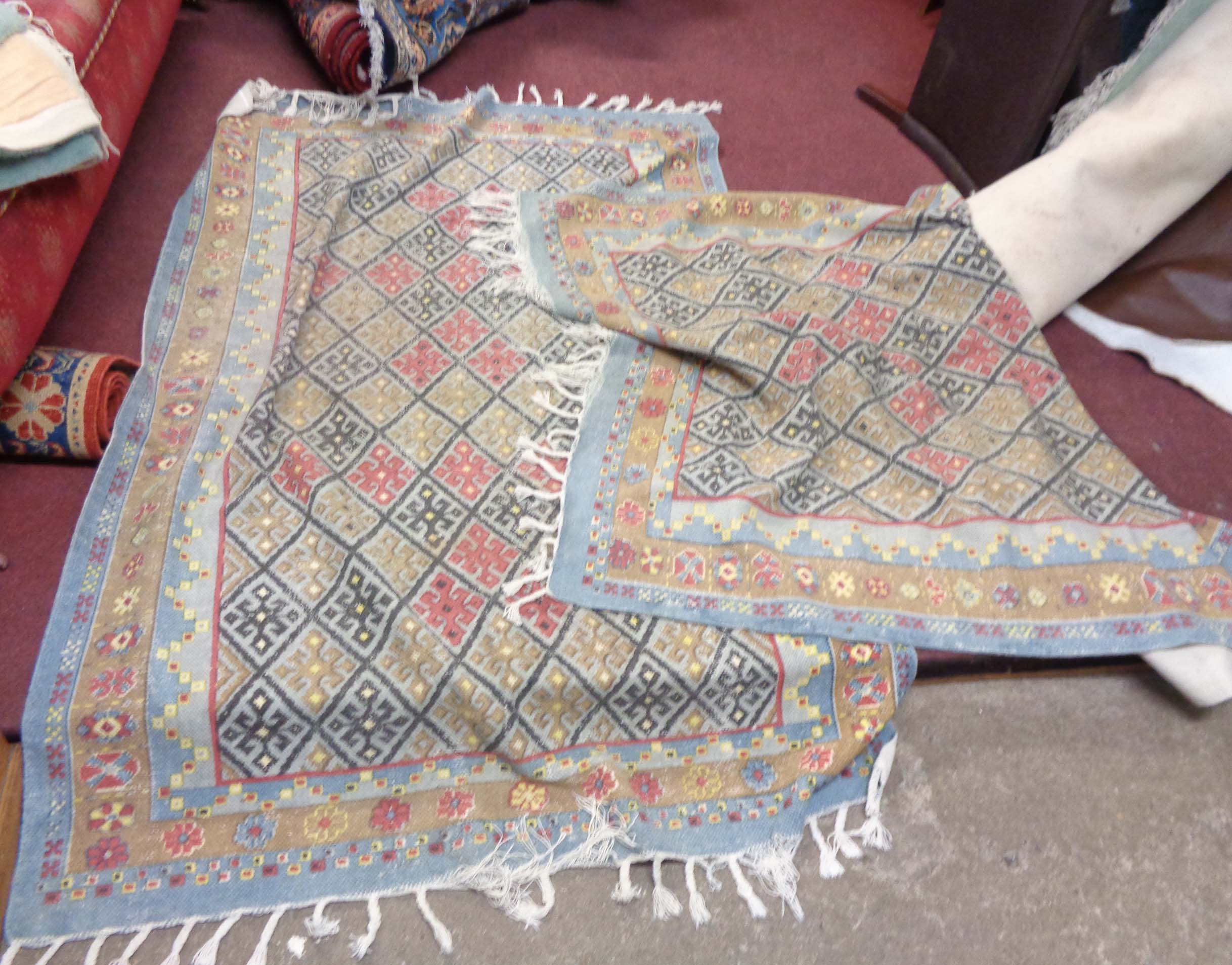 A pair of Myakka wool kilims with all over diamond decoration on pale blue ground within a triple