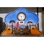 A 1920's decorative ceramic cased timepiece with printed polychrome dessert oasis scene and simple