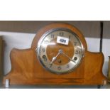 An Art Deco design mixed wood cased mantel clock with Arabic numerals, chrome plated front feet