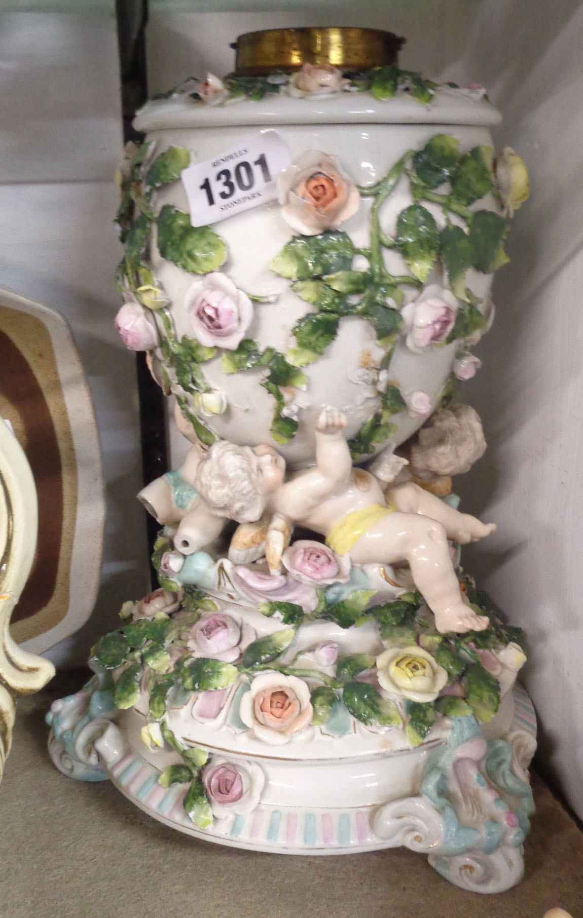 A 19th Century Sitzendorf porcelain oil lamp, the base with applied encrusted flowers and figures