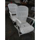 A pair of white plastic folding elbow chairs