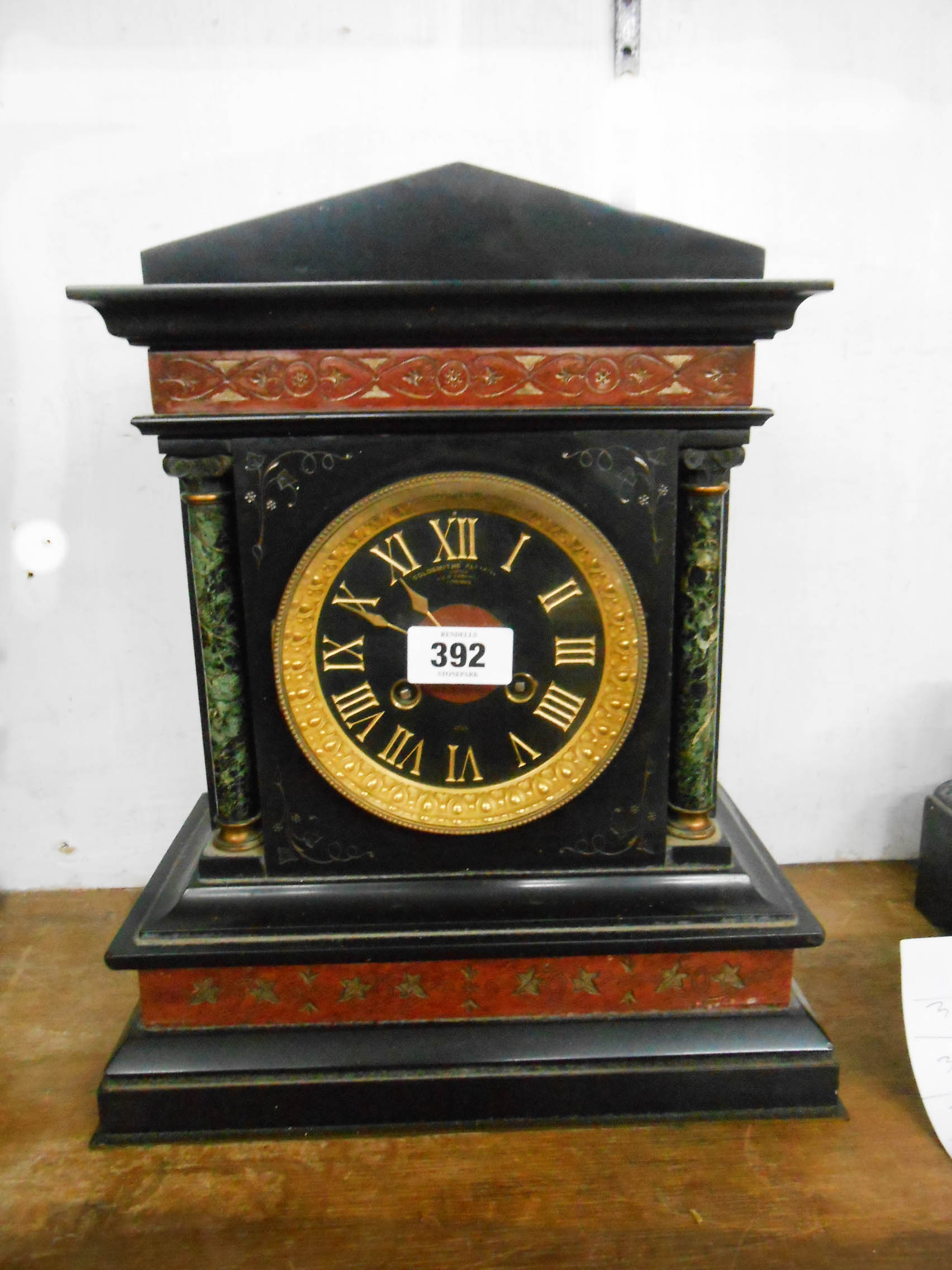 A late Victorian black slate and marble cased mantel clock of architectural design with gilt bezel