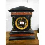 A late Victorian black slate and marble cased mantel clock of architectural design with gilt bezel