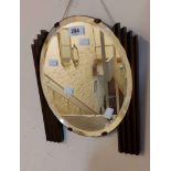 An Art Deco style small wall mirror with flanking reeded wood decoration and bevelled oval plate