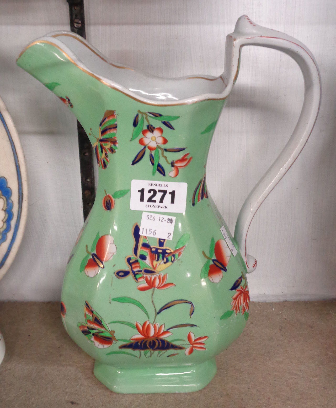 A 19th Century Ironstone jug of helmet form with transfer printed and enamel decoration on a green