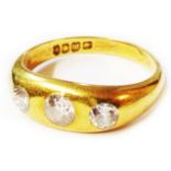 An 18ct. gold three stone gypsy set diamond ring - size Q 1/2