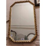 A decorative gilt framed wall mirror with canted corners