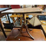 A reproduction mahogany tilt-top pedestal table with brown leather inset top, set on turned pillar