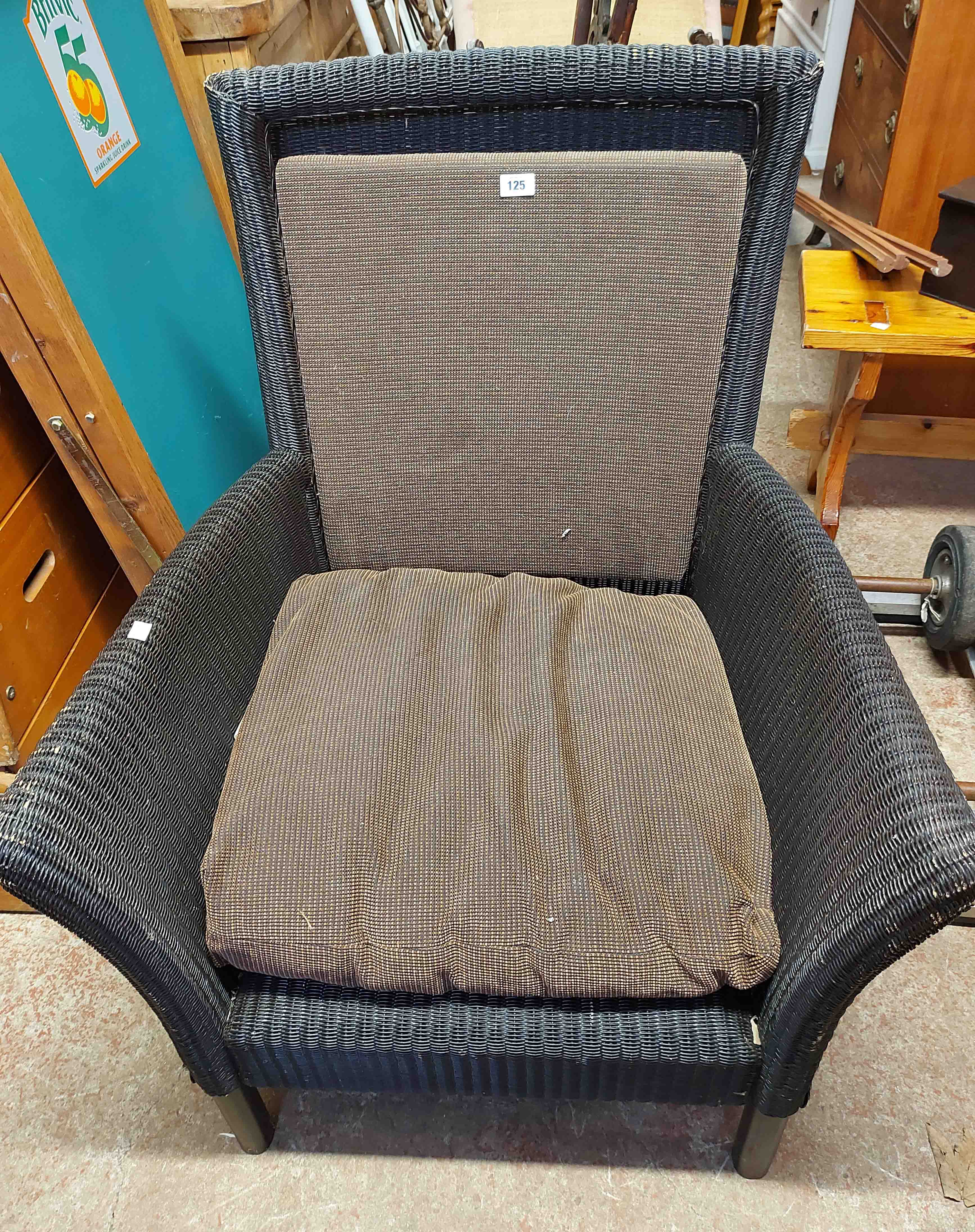 A modern Lloyd Loom armchair with upholstered back rest and cushion