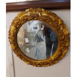 A small circular ornate gilt framed wall mirror in the antique style