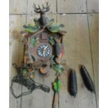 A vintage tourist ware cuckoo wall clock with painted detail, acorn pattern weights and pendulum