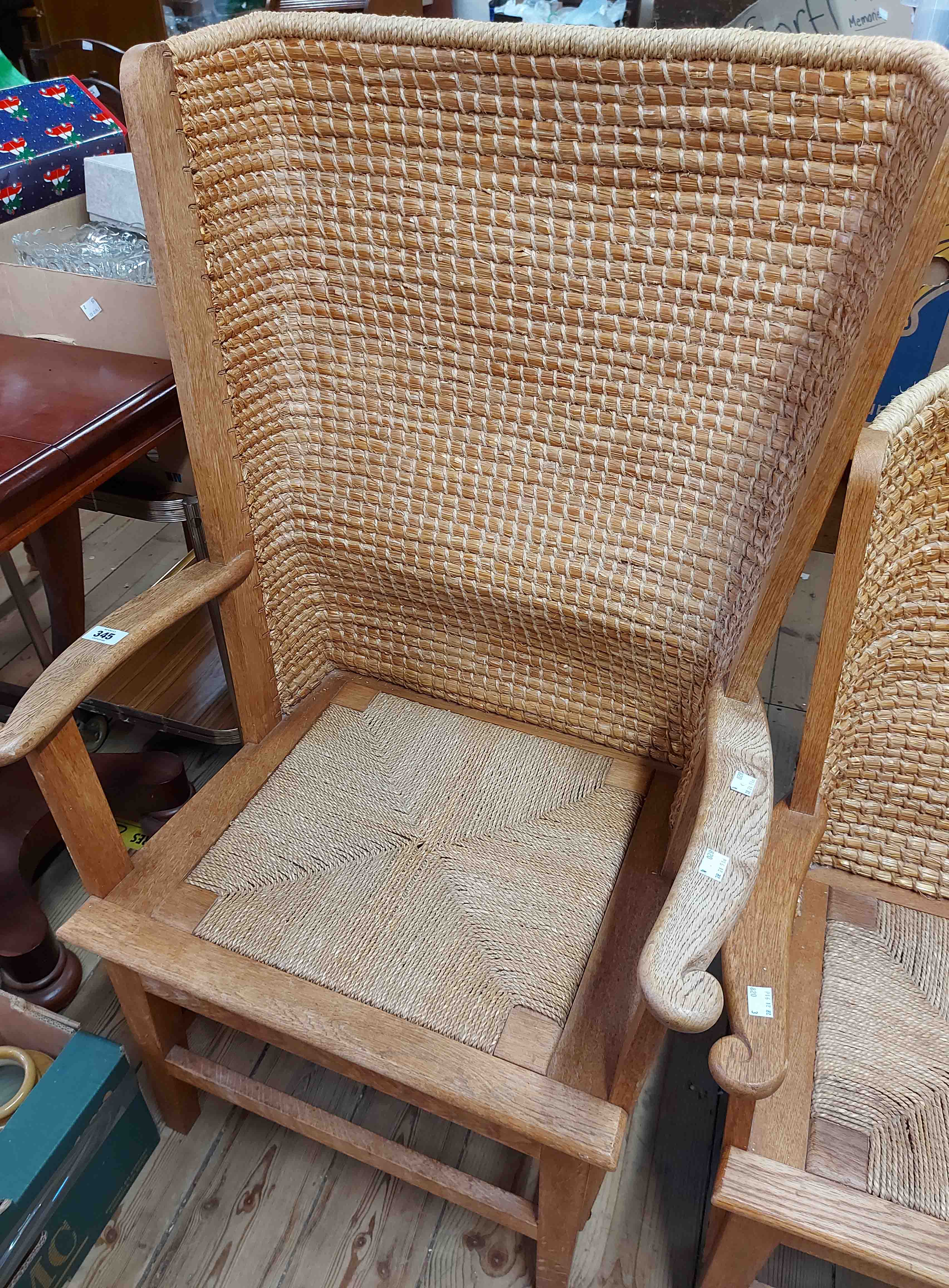 A 20th Century oak framed Orkney chair with woven and stitched curved rush back, open armrests and