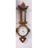 A late Victorian stained and carved oak framed aneroid wall barometer/thermometer with printed