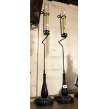 A pair of large metal candle lamps with glass shades