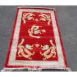 A modern Chinese silk rug with five dragons chasing flaming pearls on red ground within a