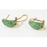 A pair of marked 9K yellow metal emerald encrusted curved panel earrings - boxed