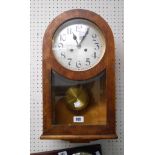 A 20th Century mahogany and mixed wood cased wall clock with bevelled glazed door, visible