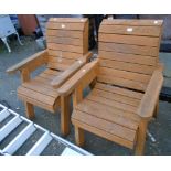 A pair of painted wood garden elbow chairs with slatted backs and seats