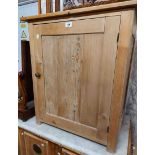 A 68cm old stripped pine cupboard with shelf enclosed by a panelled door