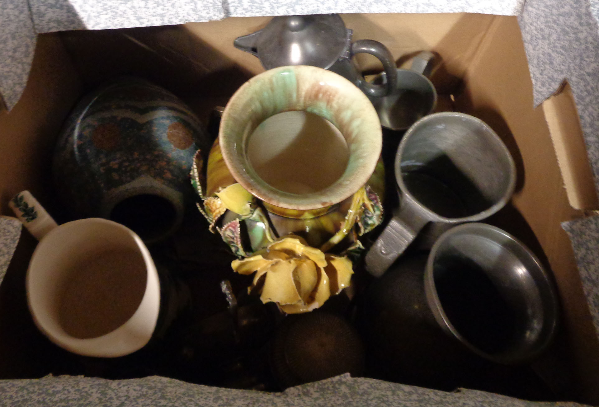 A box containing a quantity of ceramic items and pewter ware including tankards, jugs, etc.