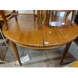 A 1.22m diameter G-Plan teak effect extending dining table with stowed folding leaf, set on