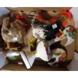 A box containing a small quantity of decorative cockerel models including ceramic and straw work