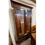 A 99cm early 20th Century stained oak book cabinet with adjustable shelves enclosed by a pair of