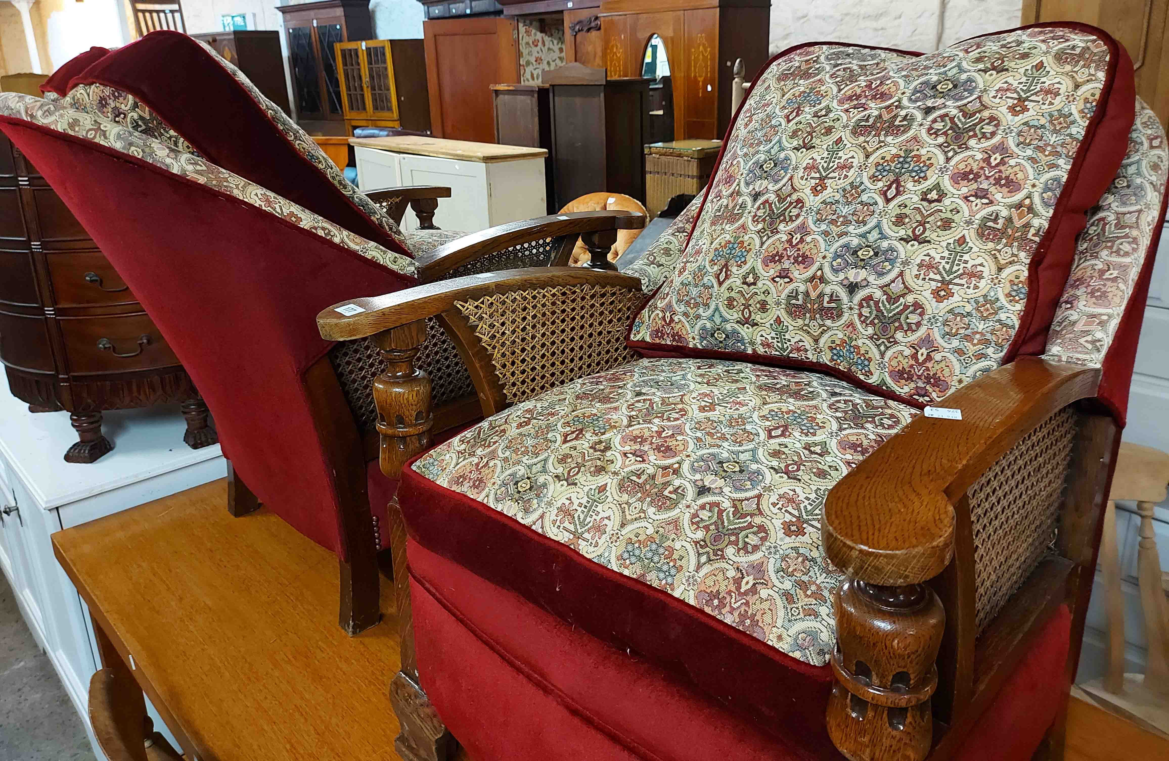 A pair of 20th Century polished oak framed tub back armchairs with bergere side panels and modern