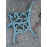 A pair of green painted wrought iron bench ends