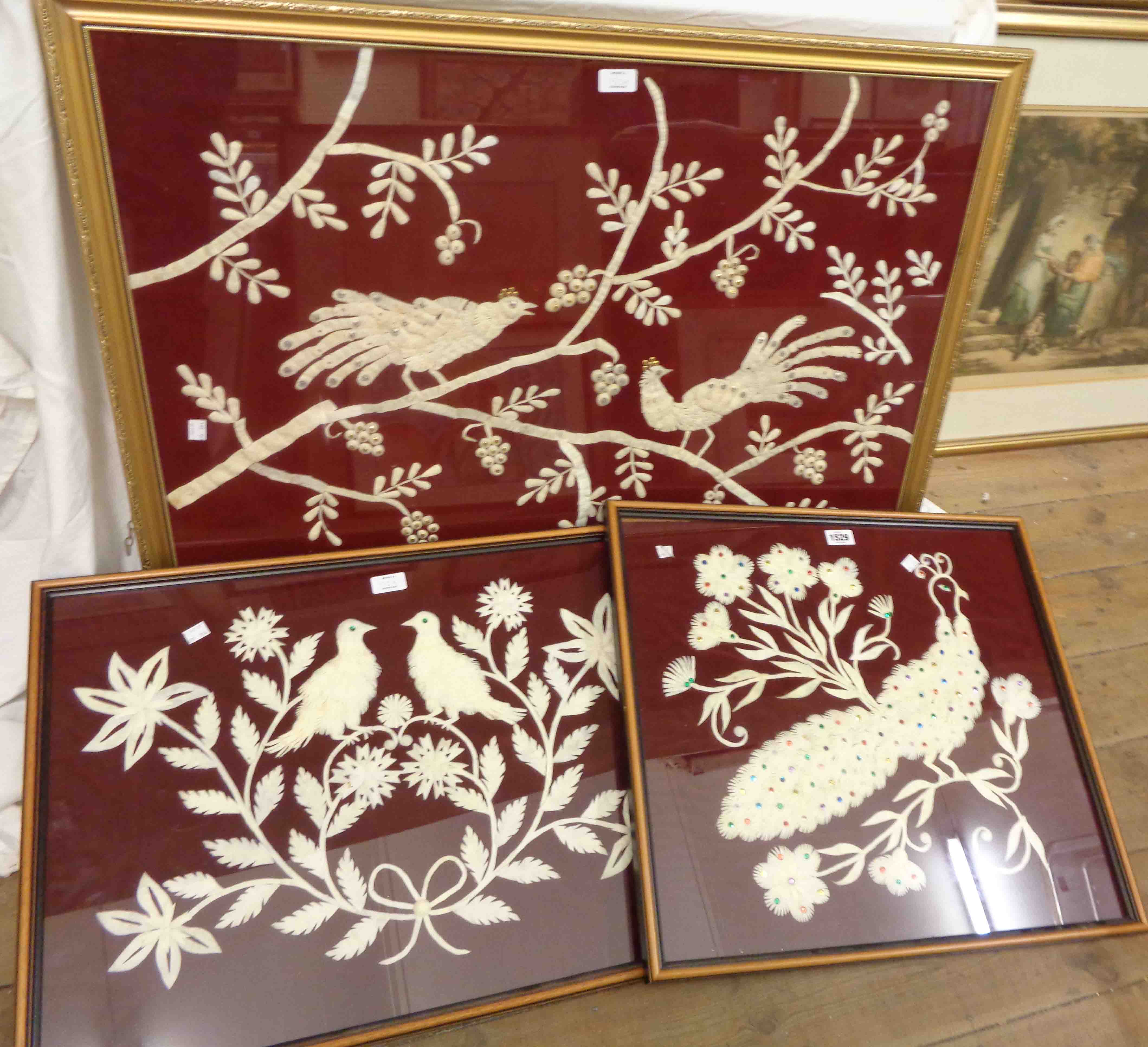 Three framed decorative embroidery pictures, all depicting perching birds