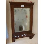 An Edwardian stained oak framed hall mirror with bevelled oblong plate and bracketed shelf under