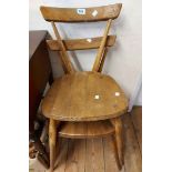 A pair of vintage Ercol light elm stacking kitchen chairs with curved back rails and solid moulded