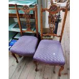 A pair of old stained wood framed standard chairs with carved top rails, pierced splat backs and