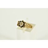 A 9CT GOLD SAPPHIRE AND DIAMOND CLUSTER RING, the cluster of a flower shape, centring on a single
