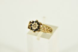 A 9CT GOLD SAPPHIRE AND DIAMOND CLUSTER RING, the cluster of a flower shape, centring on a single