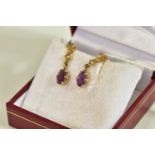 A PAIR OF 9CT GOLD AMETHYST AND SEED PEARL DROP EARRINGS, each suspending a claw set, oval cut