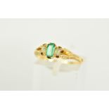 A LATE VICTORIAN EMERALD AND DIAMOND THREE STONE RING, the central baguette cut emerald flanked by