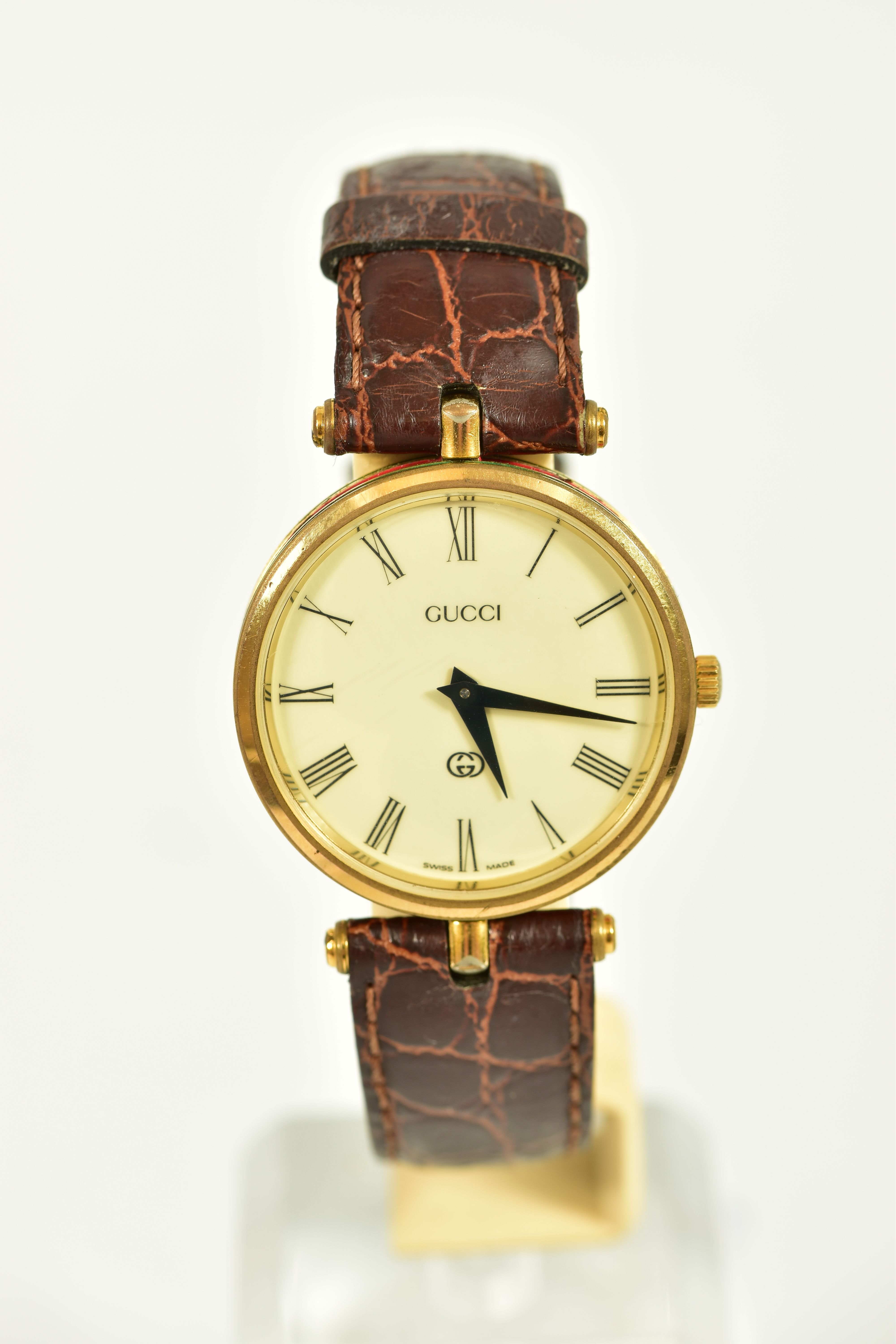 A GOLD-PLATED GUCCI QUARTZ WRISTWATCH, cream dial with roman numerals, round dial with red and green