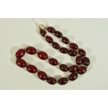 A CHERRY AMBER BEADED NECKLACE, a single row of graduated oval beads, cherry colour, individually