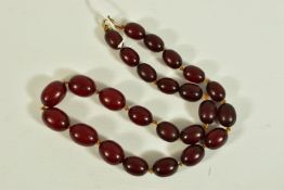 A CHERRY AMBER BEADED NECKLACE, a single row of graduated oval beads, cherry colour, individually