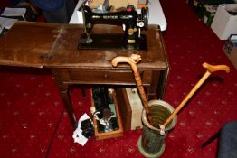 A SEWING MACHINE FROM THE SINGER MANUFACTURING CO, no Y8499586, cased in an oak table, with fall out