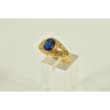 A 9CT GOLD SIGNET RING, set with an oval cut blue stone assessed as paste (loose in setting),